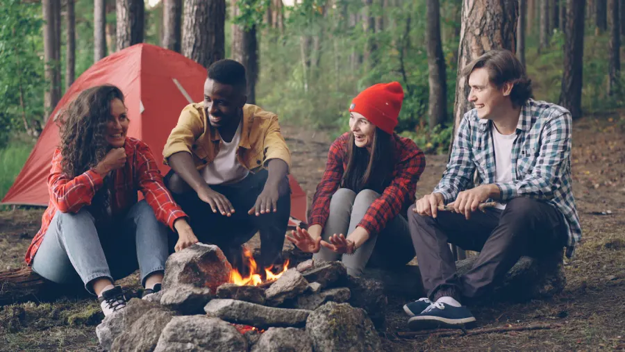 Friends sharing an evening around a campfire in the woods
