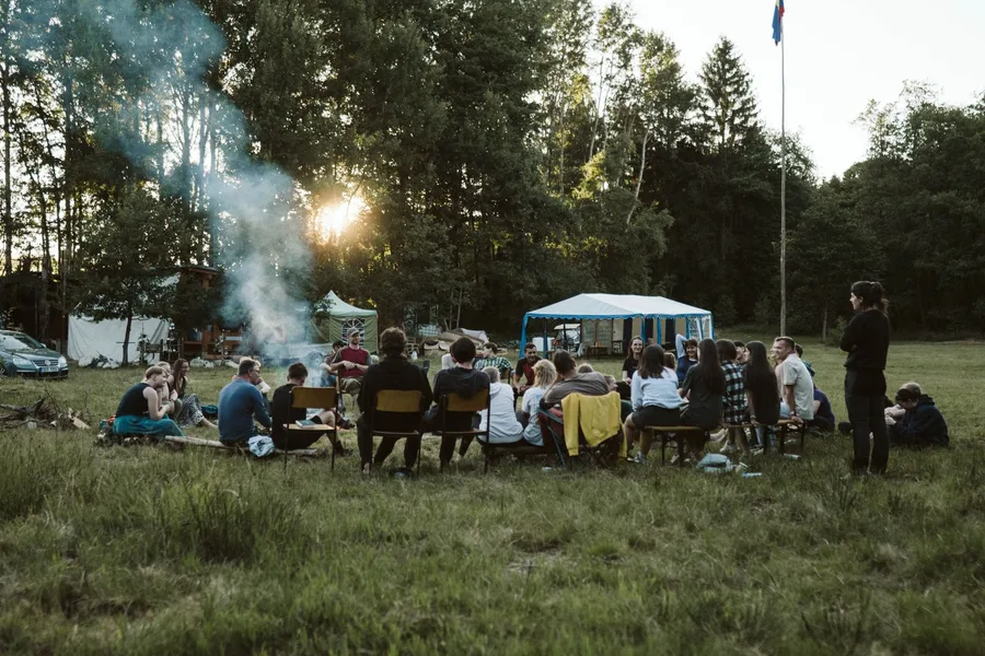 A group gathered around a campfire outdoors.