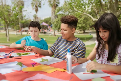 Children making art together at an outdoor table.