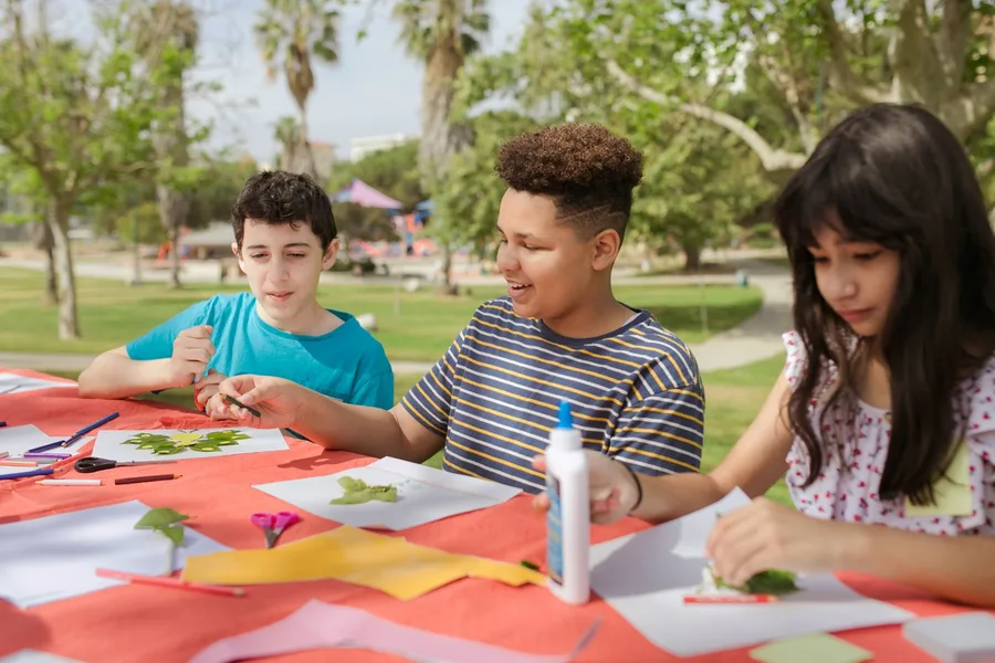 Children making art together outdoors.