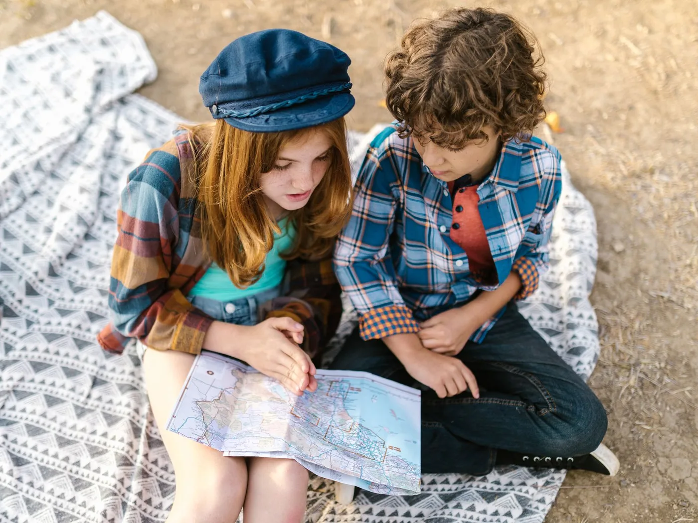 Two children looking at a map outdoors