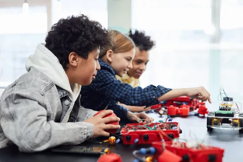 Children building a robotics project together in a classroom.