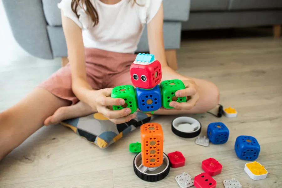 A child building a colourful toy robot