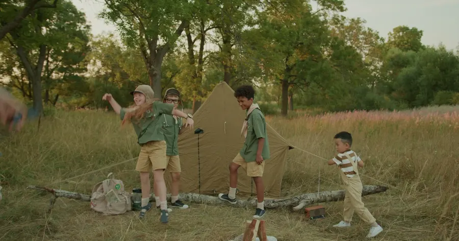 Children beside a tent on a sunny summer day